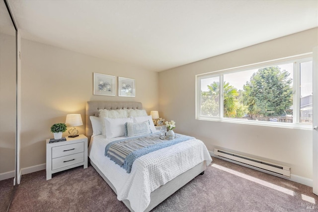 bedroom with a baseboard heating unit, carpet flooring, and baseboards