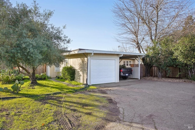 garage with driveway and fence