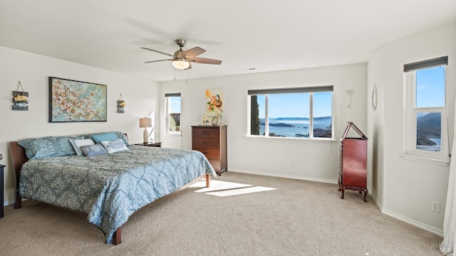 carpeted bedroom with visible vents, a ceiling fan, and baseboards