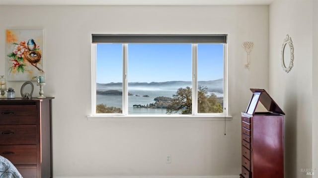 bedroom featuring a water and mountain view