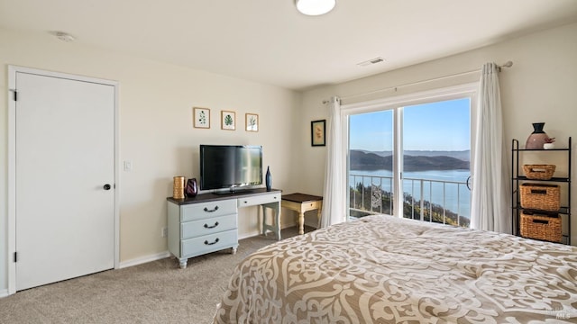 bedroom featuring baseboards, light colored carpet, visible vents, and access to exterior