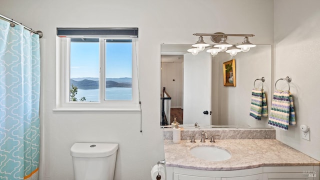 bathroom featuring toilet, curtained shower, a mountain view, and vanity