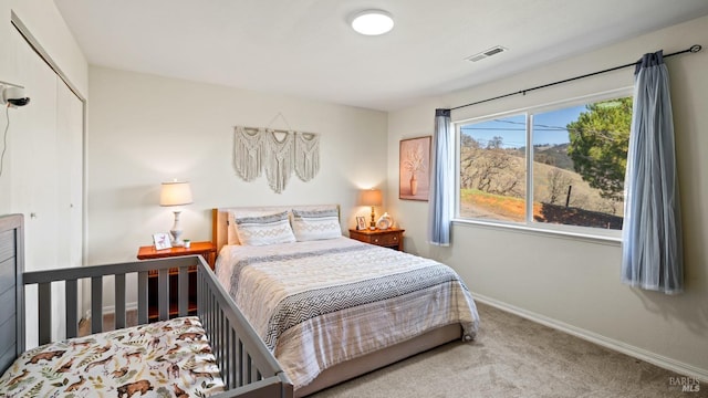 carpeted bedroom featuring visible vents, baseboards, and a closet