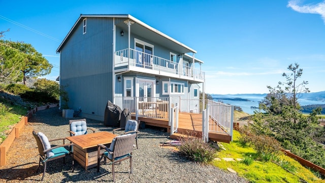 rear view of property featuring a wooden deck and a balcony