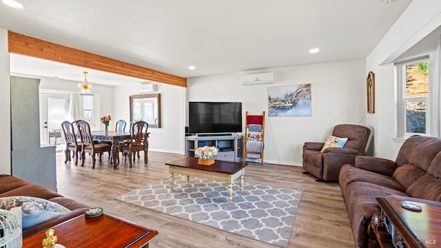 living room with recessed lighting, light wood-style flooring, beam ceiling, and a wall mounted AC