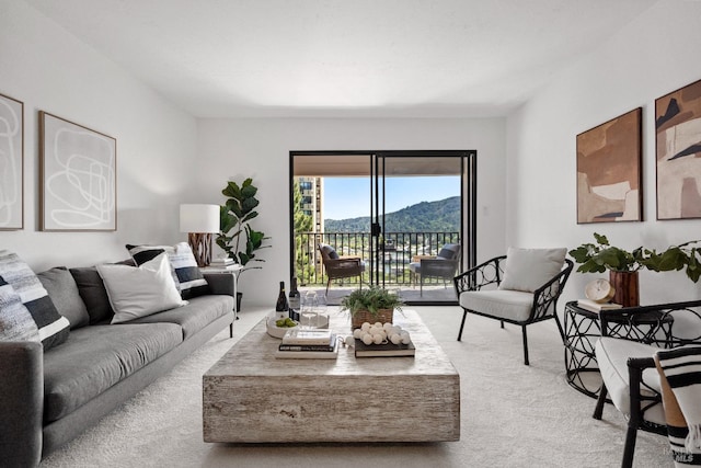 living area with light carpet and a mountain view