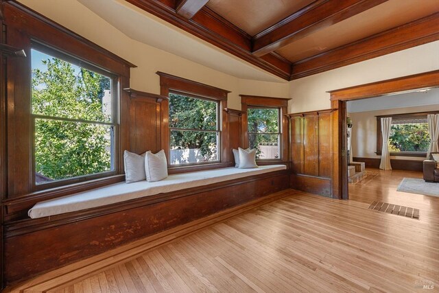 interior space with beam ceiling, crown molding, light wood finished floors, visible vents, and coffered ceiling