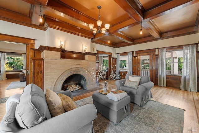 living area with coffered ceiling, a healthy amount of sunlight, and wood finished floors