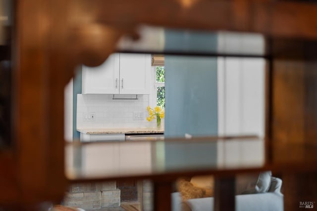 room details with white cabinetry, light countertops, and backsplash