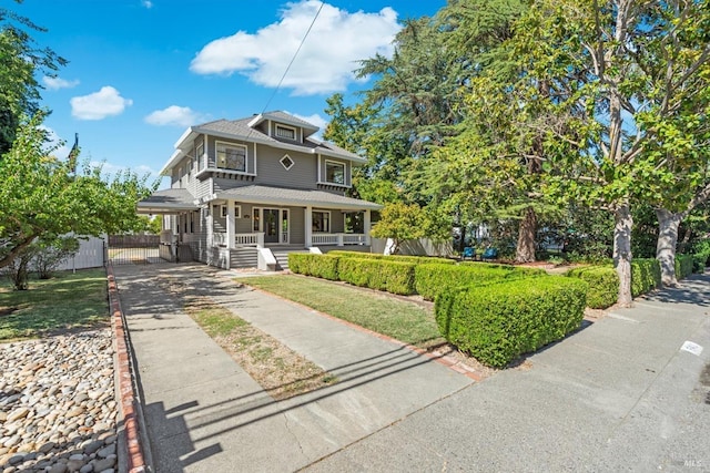 american foursquare style home with a porch and fence