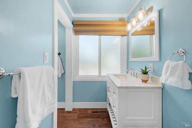 bathroom featuring crown molding, visible vents, vanity, wood finished floors, and baseboards