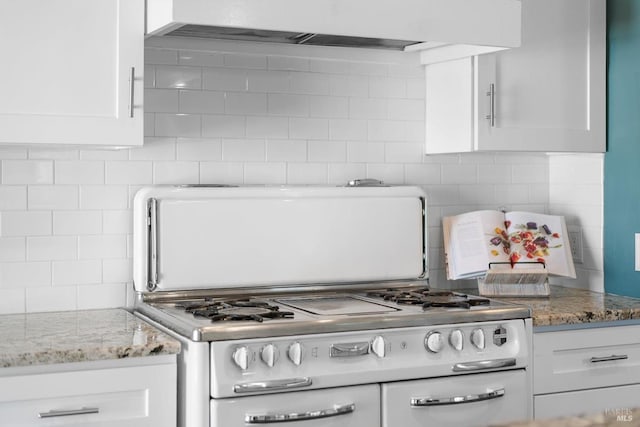 kitchen with tasteful backsplash, stone countertops, white cabinetry, and double oven range