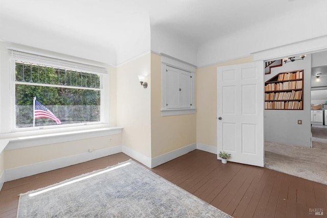 interior space featuring baseboards and wood finished floors