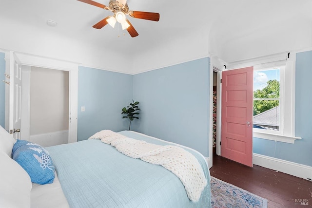 bedroom with ceiling fan, baseboards, and dark wood-type flooring