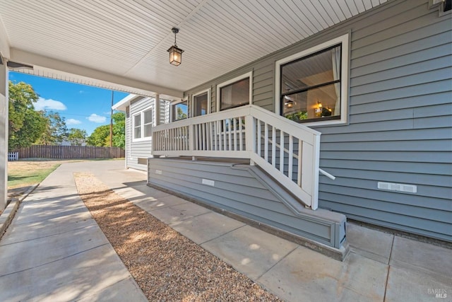 exterior space featuring covered porch and fence