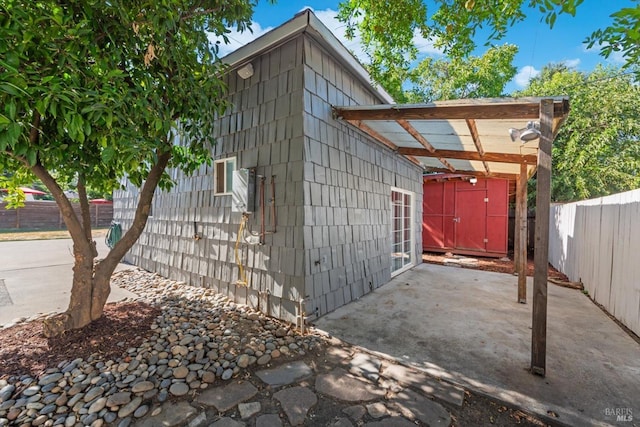 view of outbuilding with a carport and fence private yard