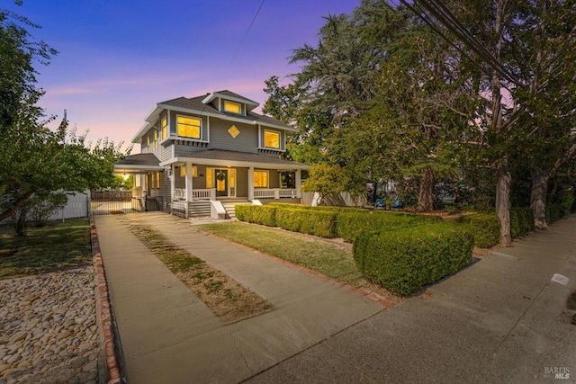 traditional style home featuring a porch, fence, and driveway