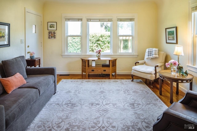 living area featuring light wood-style floors, visible vents, and baseboards