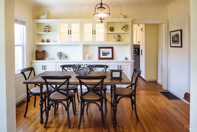 dining space featuring visible vents, baseboards, and wood finished floors