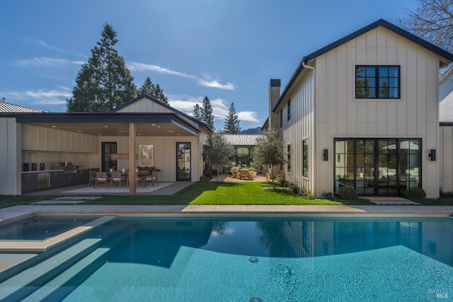 rear view of house with a patio, board and batten siding, outdoor dining space, an in ground hot tub, and an outdoor pool