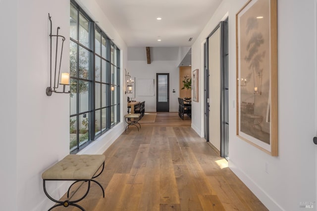 hall with plenty of natural light, baseboards, hardwood / wood-style floors, and recessed lighting