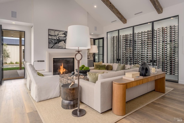 living room featuring high vaulted ceiling, beamed ceiling, and wood finished floors