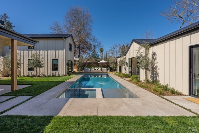 outdoor pool featuring a patio and a lawn