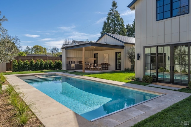 view of pool featuring a patio, an in ground hot tub, fence, a yard, and a fenced in pool