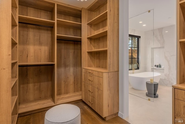 full bathroom featuring a freestanding tub, a sauna, and wood finished floors