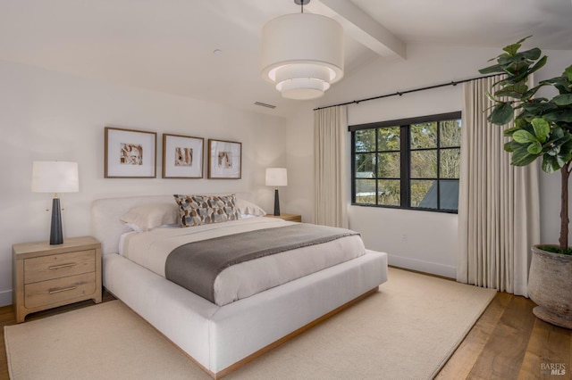 bedroom featuring lofted ceiling with beams, wood finished floors, visible vents, and baseboards