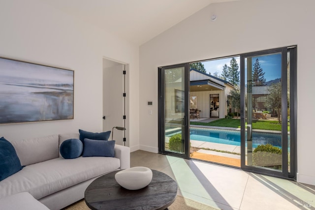 living room featuring lofted ceiling, baseboards, and tile patterned floors