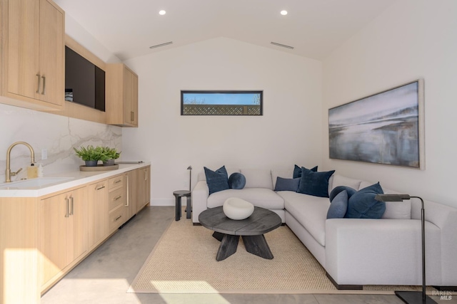 living area featuring lofted ceiling, visible vents, finished concrete flooring, and recessed lighting