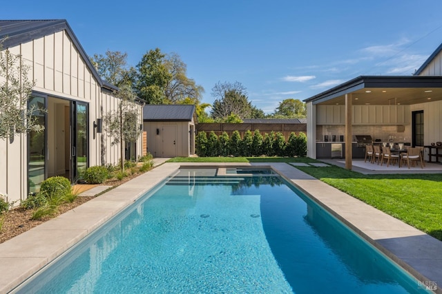 view of swimming pool with a fenced in pool, an outbuilding, a patio, and a storage shed