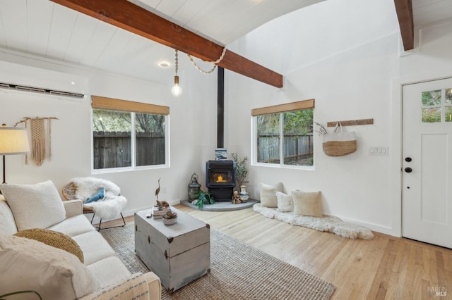 living area featuring beamed ceiling, wood finished floors, and a wealth of natural light