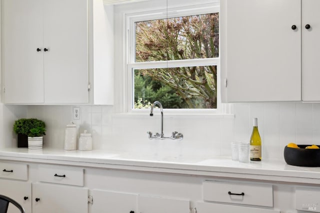 kitchen featuring plenty of natural light, white cabinets, and decorative backsplash