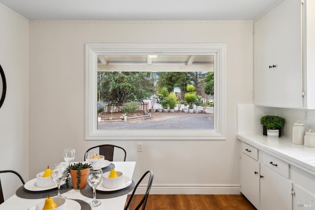 dining space featuring wood finished floors and baseboards