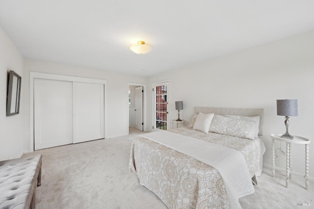 bedroom featuring light carpet, baseboards, and a closet