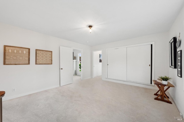 interior space featuring light carpet, a closet, and baseboards