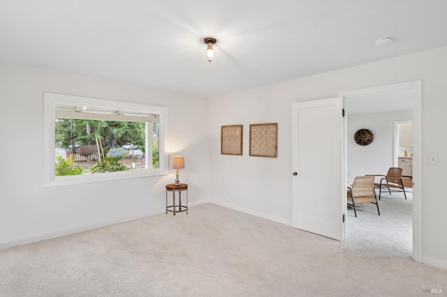 unfurnished room featuring light carpet and baseboards