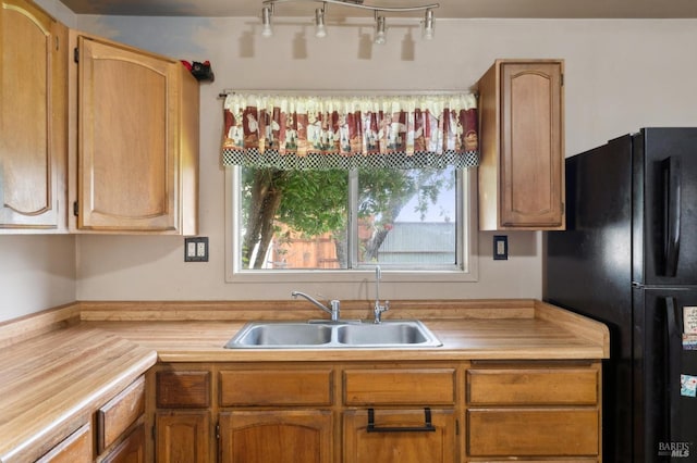 kitchen featuring light countertops, a sink, and freestanding refrigerator