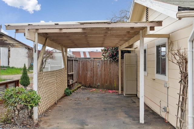 view of patio featuring a carport and fence