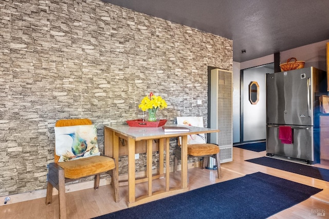 interior space with freestanding refrigerator and wood finished floors