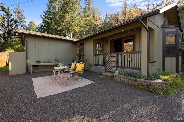 rear view of property featuring covered porch and a patio