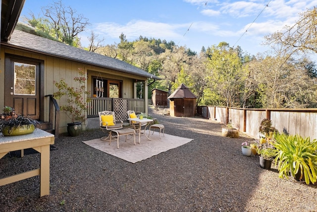 view of patio featuring a fenced backyard, an outdoor structure, and a storage unit