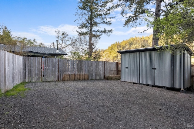 view of yard with a storage shed, an outdoor structure, and a fenced backyard