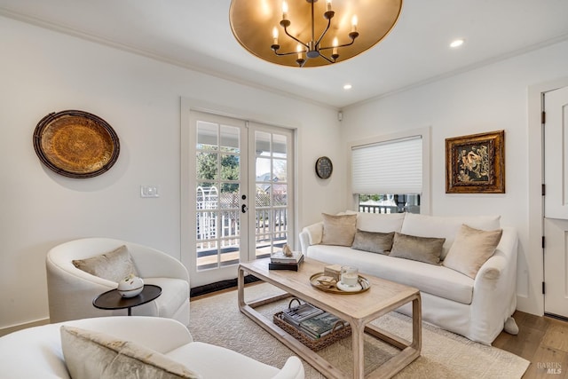 living room featuring ornamental molding, french doors, a chandelier, and light wood-style flooring