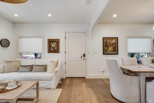 living room with light wood-type flooring, crown molding, and recessed lighting