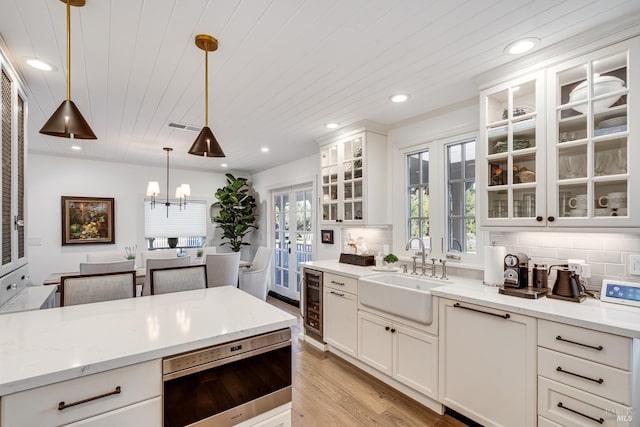 kitchen with tasteful backsplash, wood ceiling, decorative light fixtures, and a sink