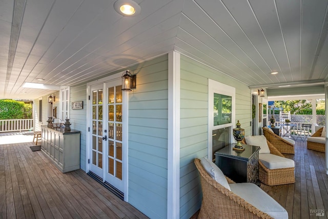 wooden terrace featuring covered porch and french doors