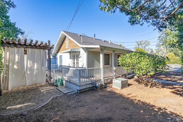 back of house with roof with shingles, a patio area, fence, and a wooden deck